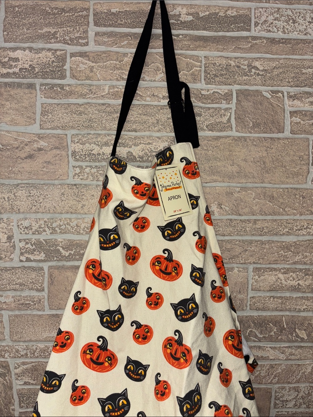 Viral Johanna Parker apron, orange pumpkins, black cat cream background